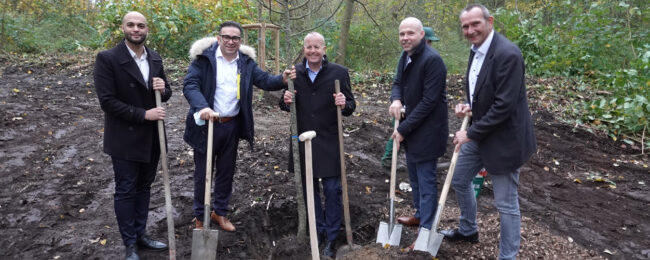 Gruppenbild von Piepenbrock Mitarbeitern Ussama Ghoneim, Mahmut Tümkaya und Thorsten Seewöster sowie ThyssenKrupp Mitarbeiter mit Spaten in der Hand bei Baumpflanzaktion.