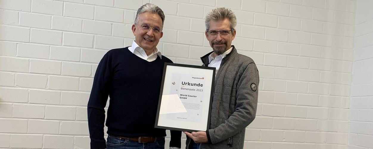 Reiner Diehlmann und Frank Runkel bei Übergabe einer Urkunde zur Bienenpatenschaft