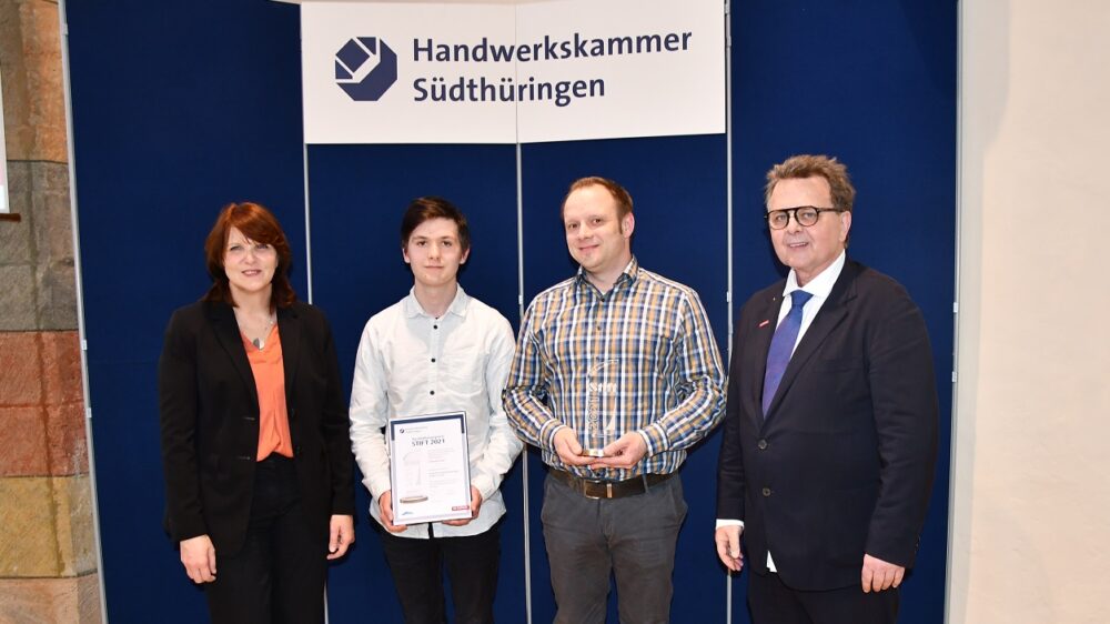 Vertreter der Handwerkskammer Südthüringen überreichen den „Stift 2021“-Preis für die besten Ausbildungsbetriebe an den Piepenbrocker Tim Böhning.