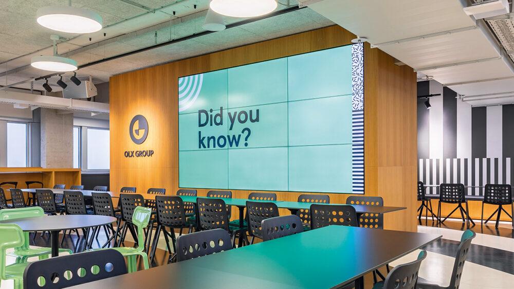 Konferenzraum bei der OLX Group mit Sicht auf großen Bildschirm