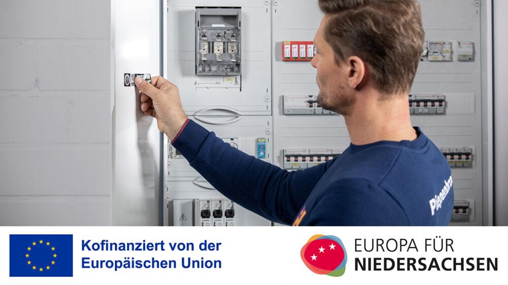 Piepenbrock Mitarbeiter mit blauem Sweatshirt bei der Betriebsmittelprüfung mit Logo der Europäischen Union zur Kofinanzierung