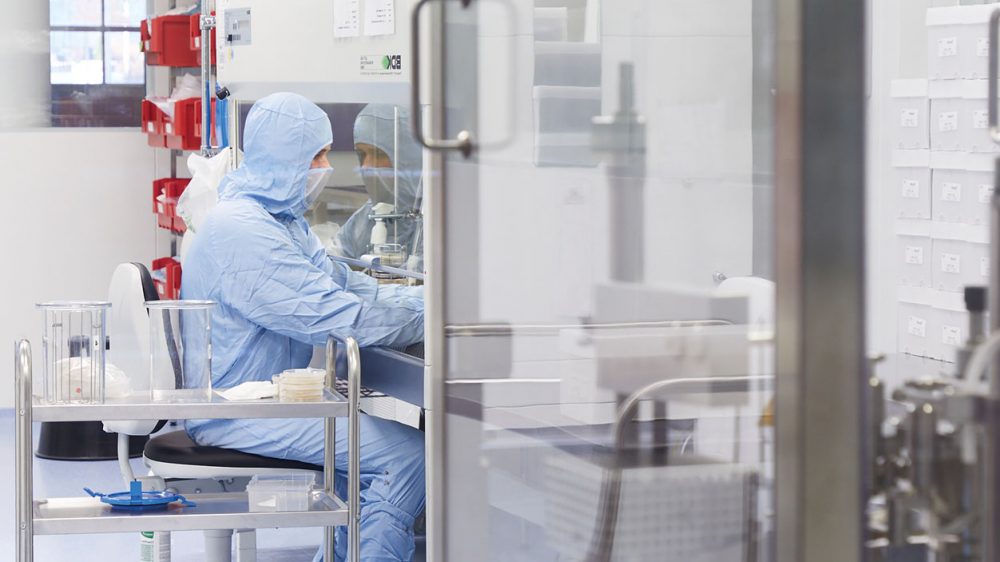 Reinraummitarbeiter in kompletter Schutzkleidung im Labor