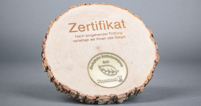 Ein Siegel "Ökologische Gebäudereinigung" in Gold.