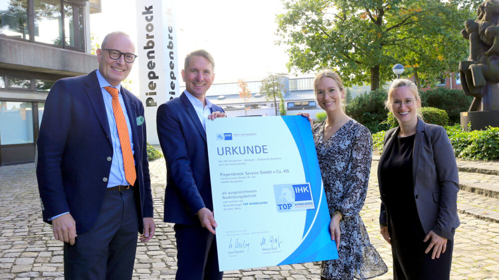 Gruppenbild Arnulf Piepenbrock und Mitarbeiter mit Urkunde zum Top-Ausbildungsbetrieb auf dem Unternehmensgelände in Osnabrück