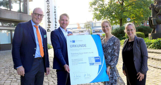 Gruppenbild Arnulf Piepenbrock und Mitarbeiter mit Urkunde zum Top-Ausbildungsbetrieb auf dem Unternehmensgelände in Osnabrück