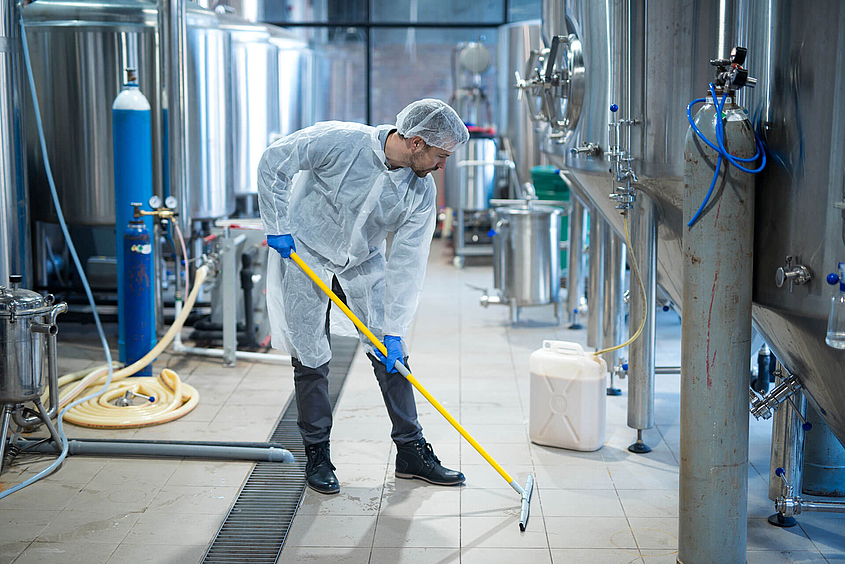 Mitarbeiter führt Reinigung in der Lebensmittelindustrie durch