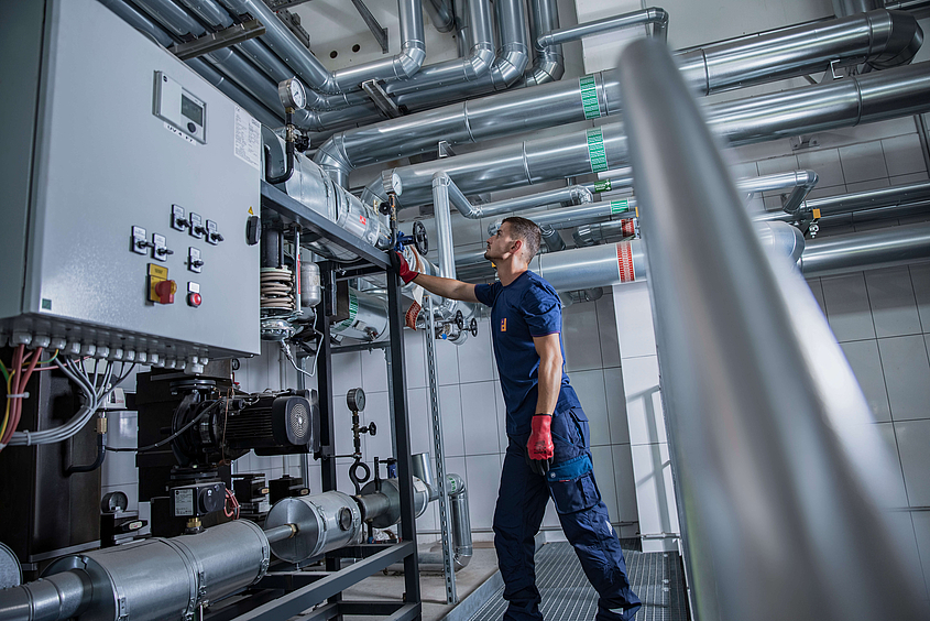 Ein Mitarbeiter von Piepenbrock führt die Prüfung einer elektrischen Maschine durch