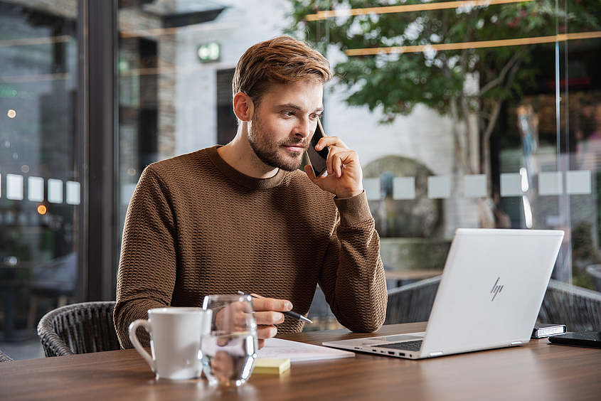 Definition von Computer Aided Facility Management Mitarbeiter telefoniert am Laptop
