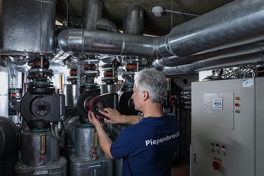 Facility Management Mitarbeiter von Piepenbrock überprüft Pumpen