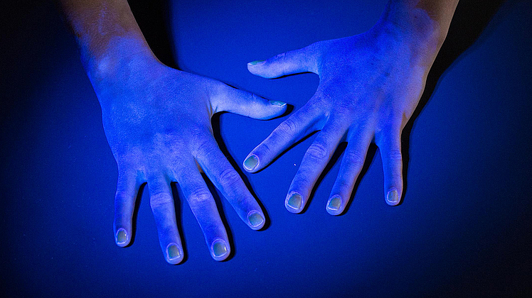 Zwei hände unter Schwarzlicht