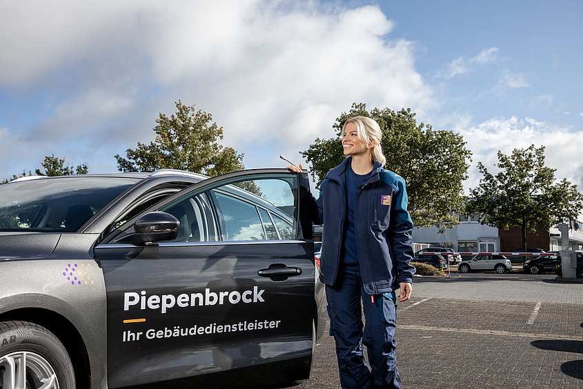 Mitarbeiterin der DGUV3-Prüfung mit ihrem Firmenwagen