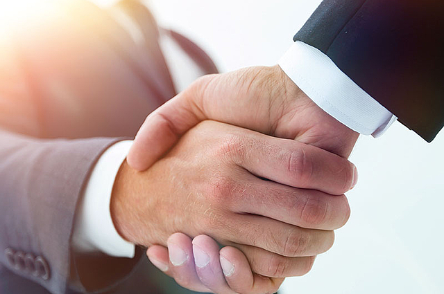 Handschlag zwischen zwei Personen im Anzug