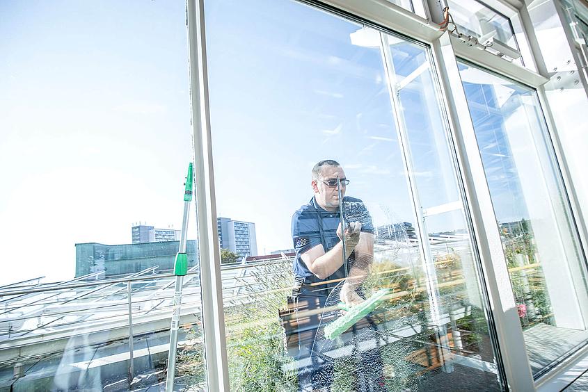 Mitarbeiter führt Fenster- und Gebäudereinigung aus