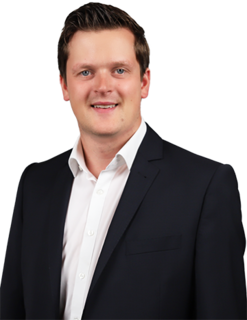 Portraitbild von Piepenbrock Niederlassungsleiter Jörn Konieczny in schwarzem Sakko und weißem Hemd