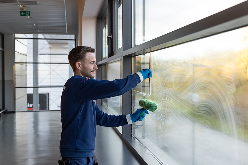 Mitarbeiter reinigt Fenster