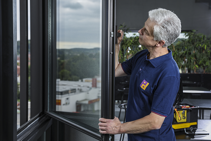 Definition von Hausmeisterservice Aufgaben Piepenbrock-Mitarbeiter prüft Fenster