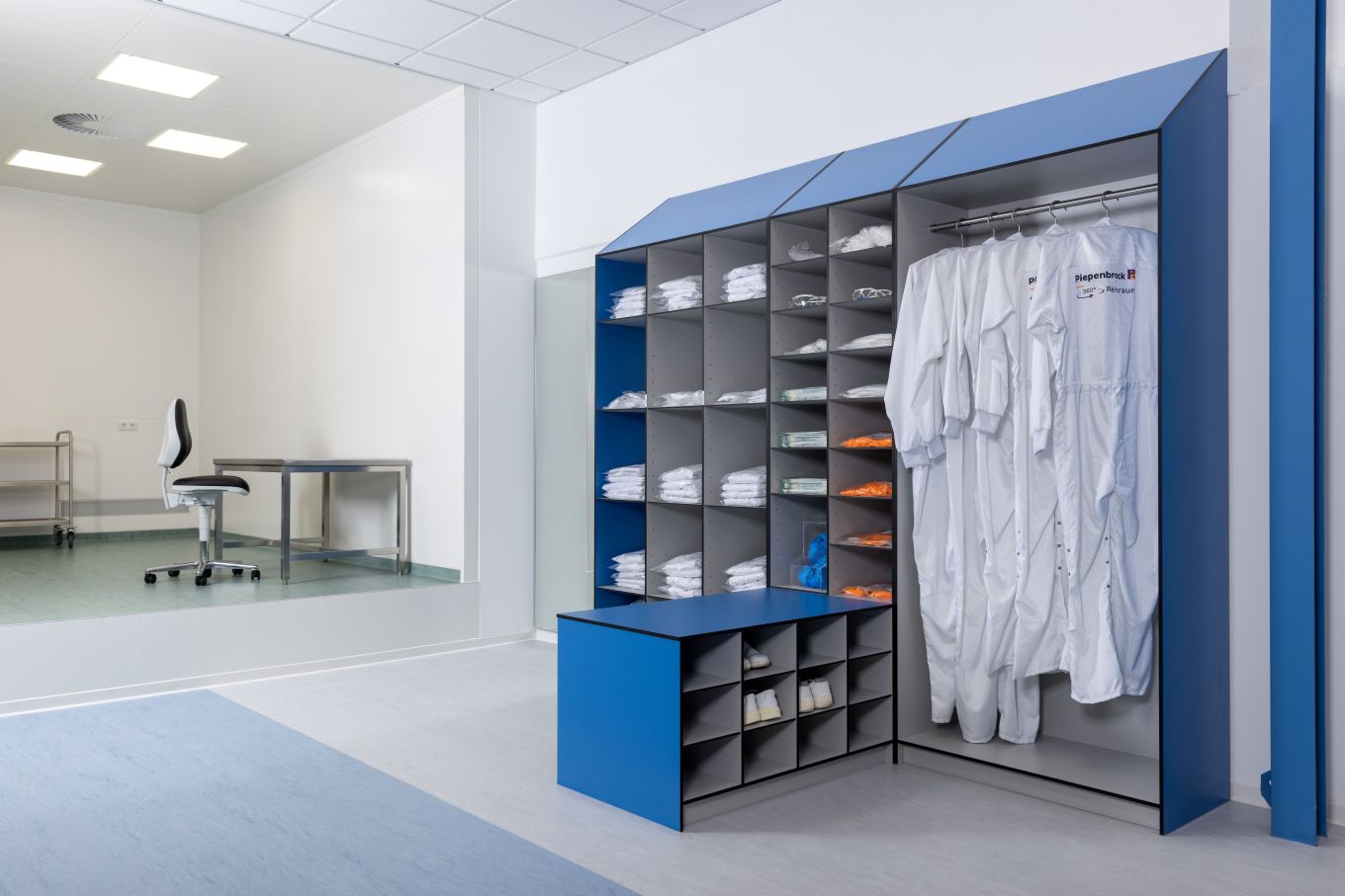 Reinraum Umkleidebereich mit Schutzkleidung, strukturiertes Schranksystem und hygienische Arbeitsumgebung